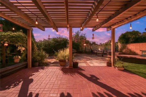 a outdoor view of a patio with a table and chairs under an umbrella