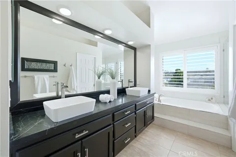 a white bath tub sitting in a bathroom next to a window