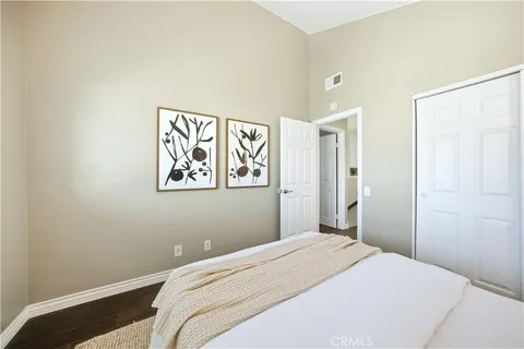 a bedroom with a bed window and wooden floor