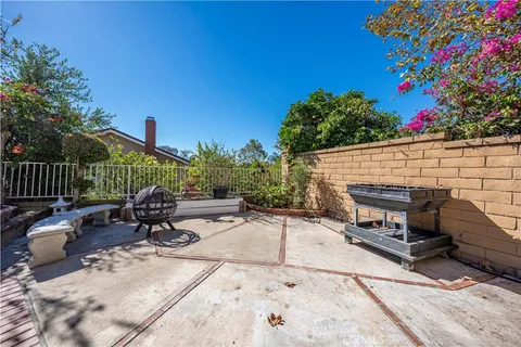 a patio with table and chairs and potted plants