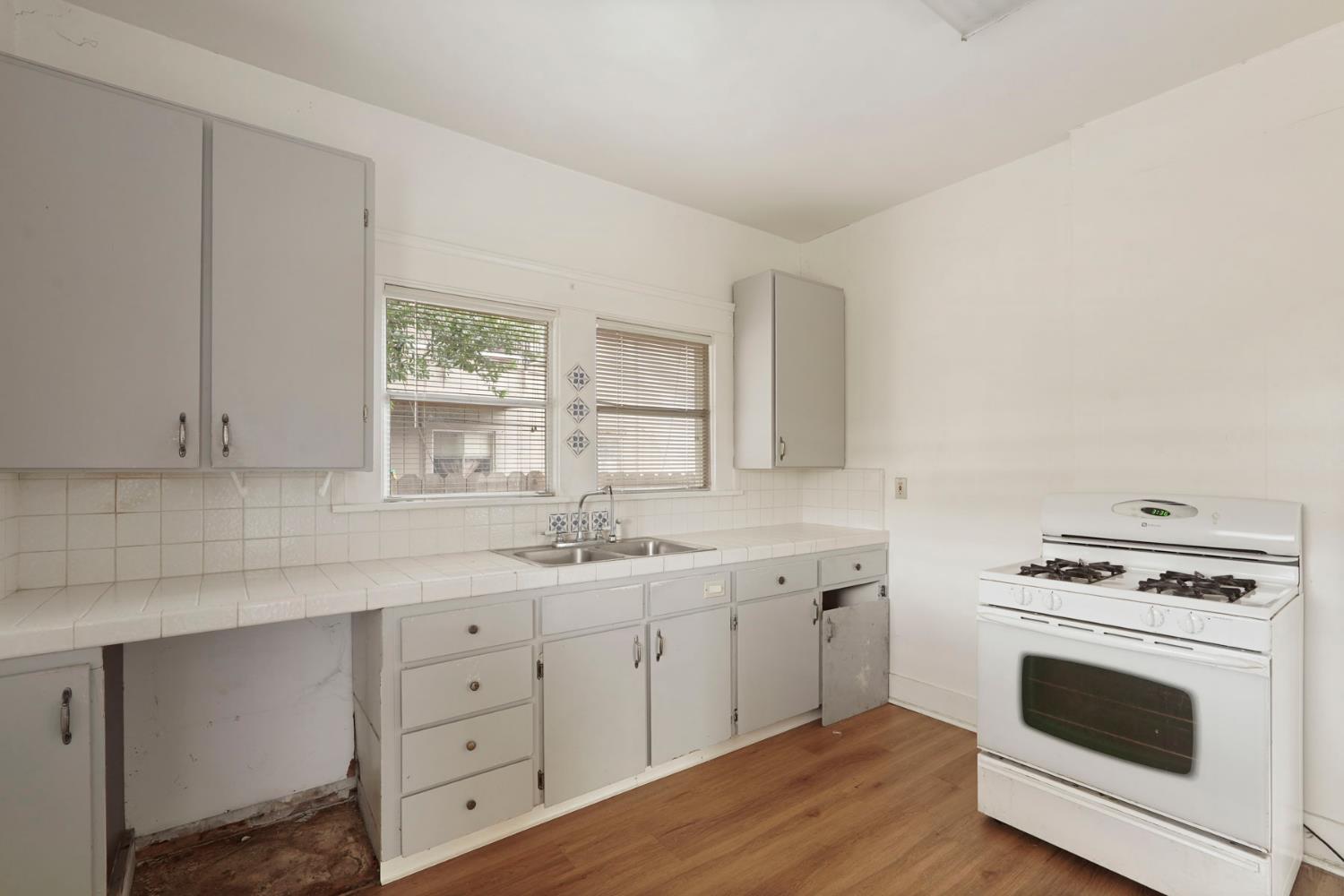 400 Chestnut Street Lodi, CA 95240 - Photo 26 of 36 a kitchen with cabinets stainless steel appliances a sink and wooden floor