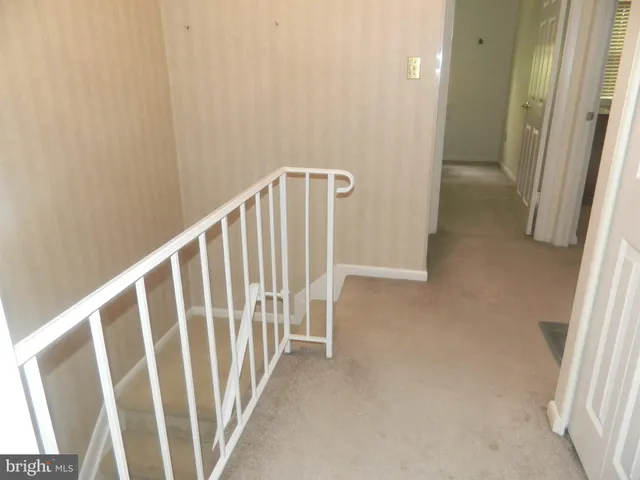 a patio with table and chairs and potted plants