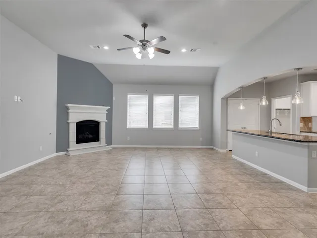 a view of an empty room with window and fireplace