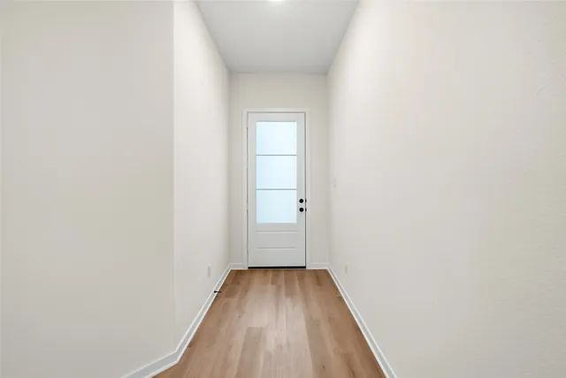 a view of a hallway with wooden floor