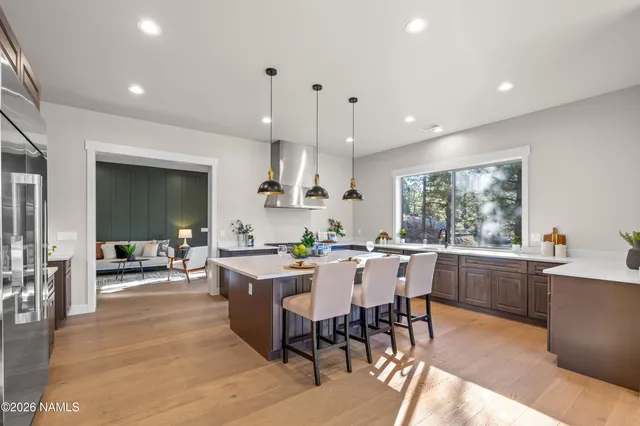 a living room with furniture kitchen view and a flat screen tv