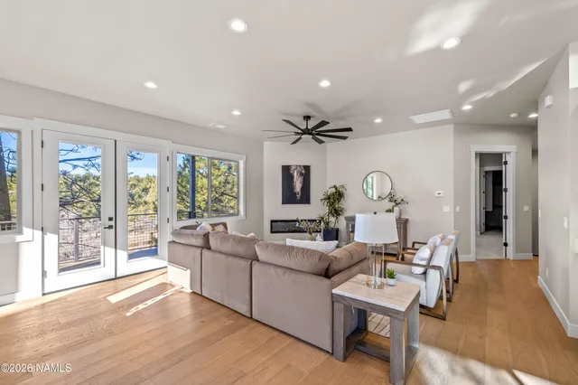 a view of a refrigerator in kitchen and an empty room with wooden floor