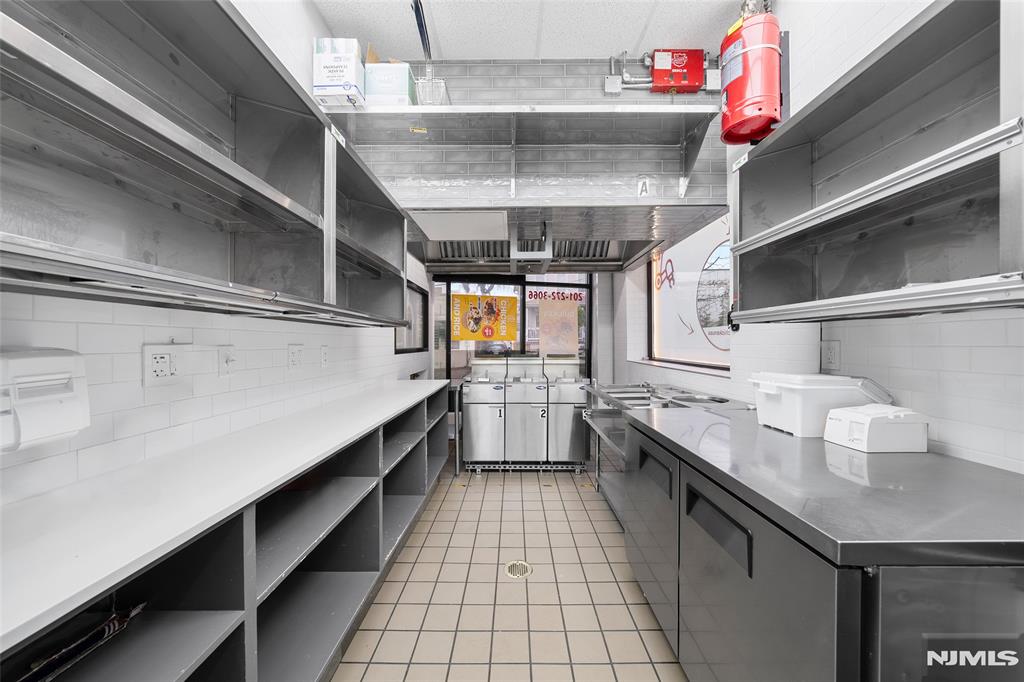 69-71 Ridgefield Avenue Ridgefield Park, NJ 07660 - Photo 14 of 37 a kitchen with granite countertop lots of white stainless steel appliances a sink and cabinets