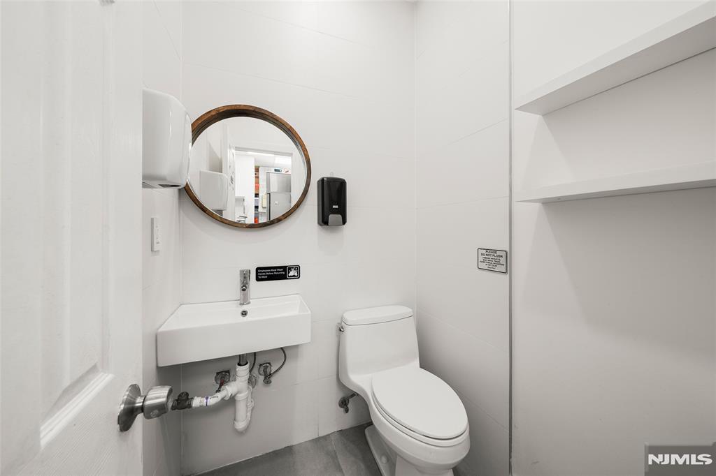 69-71 Ridgefield Avenue Ridgefield Park, NJ 07660 - Photo 18 of 37 a bathroom with a toilet a sink and a mirror