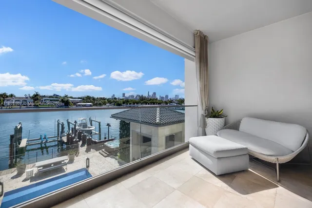 a view of a white house with a yard and potted plants