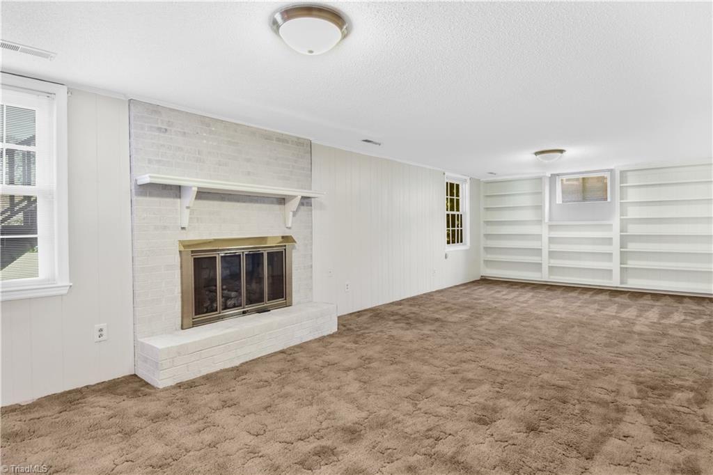 546 Drumheller Road Clemmons, NC 27012 - Photo 21 of 29 Huge bonus/playroom on lower level with full wall of shelves and gas log fireplace,