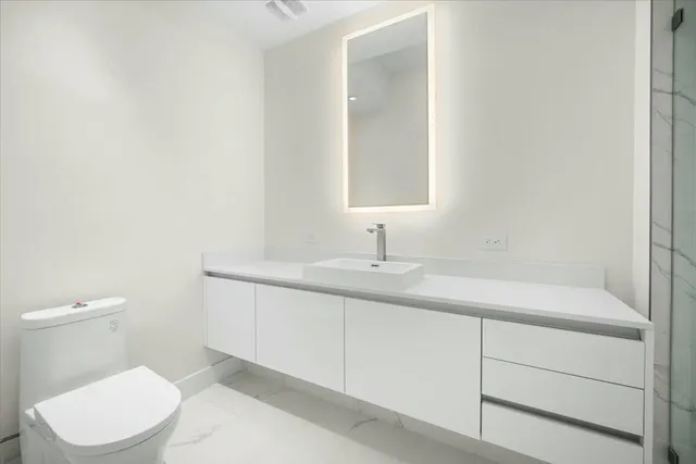 a bathroom with a toilet sink and mirror