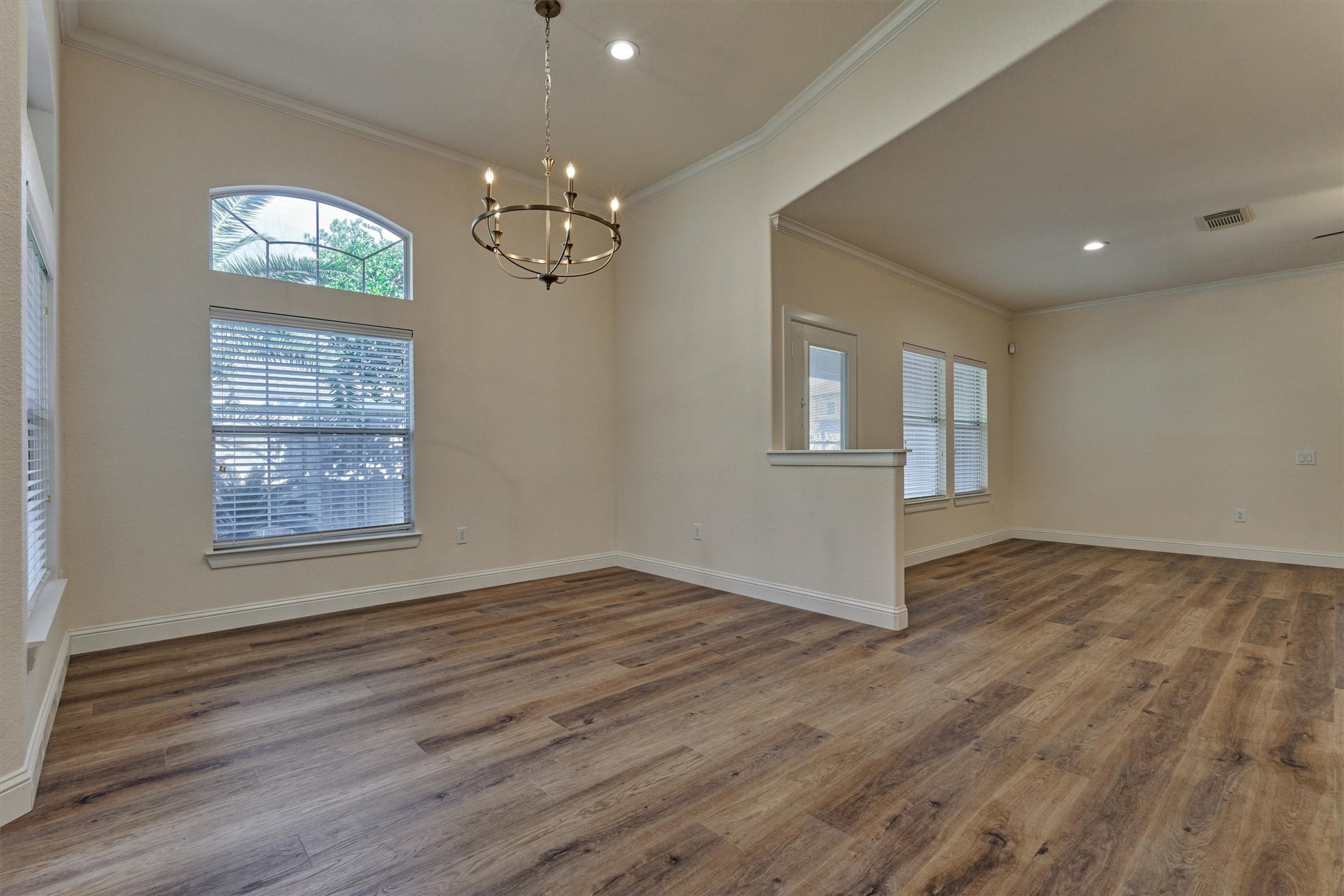 6 Windsor Bridge Drive Conroe, TX 77384 - Photo 13 of 46 an empty room with wooden floor chandelier and windows