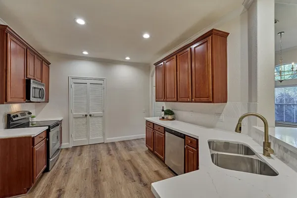 a kitchen with sink cabinets and wooden floor