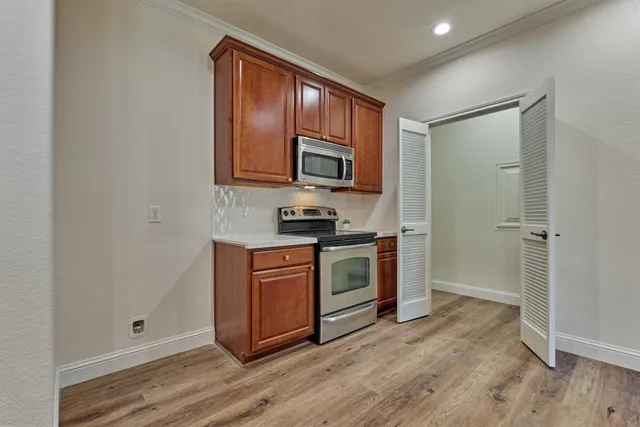 a kitchen with granite countertop wooden cabinets and stainless steel appliances