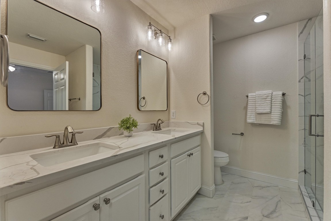 6 Windsor Bridge Drive Conroe, TX 77384 - Photo 19 of 46 Relax in this LUXURIOUS en-suite bathroom! This primary bathroom has been recently renovated and shows beautifully! All new quartz counters, new shower, modern tile and all new lighting, hardware and mirrors. This is a spacious primary suite with a large walk in glass shower.