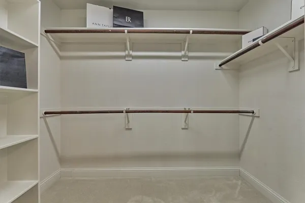 an empty room with wooden floor chandelier fan and windows