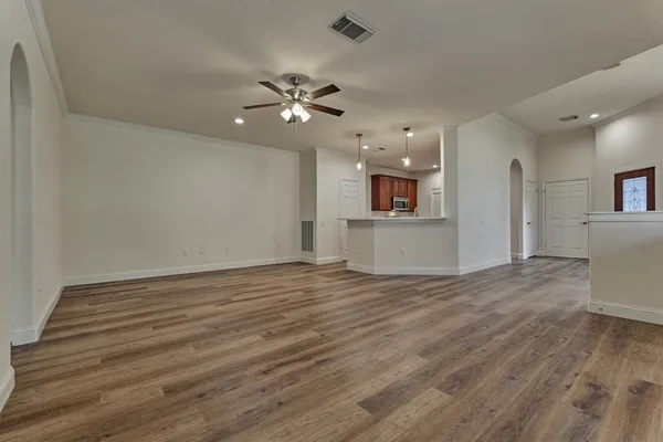 an empty room with windows and fan