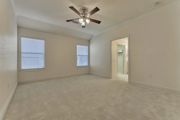 an empty room with a window and a fan