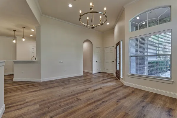 a view of empty room with wooden floor and window