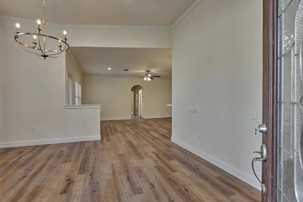 a view of a room with wooden floor and ceiling fan