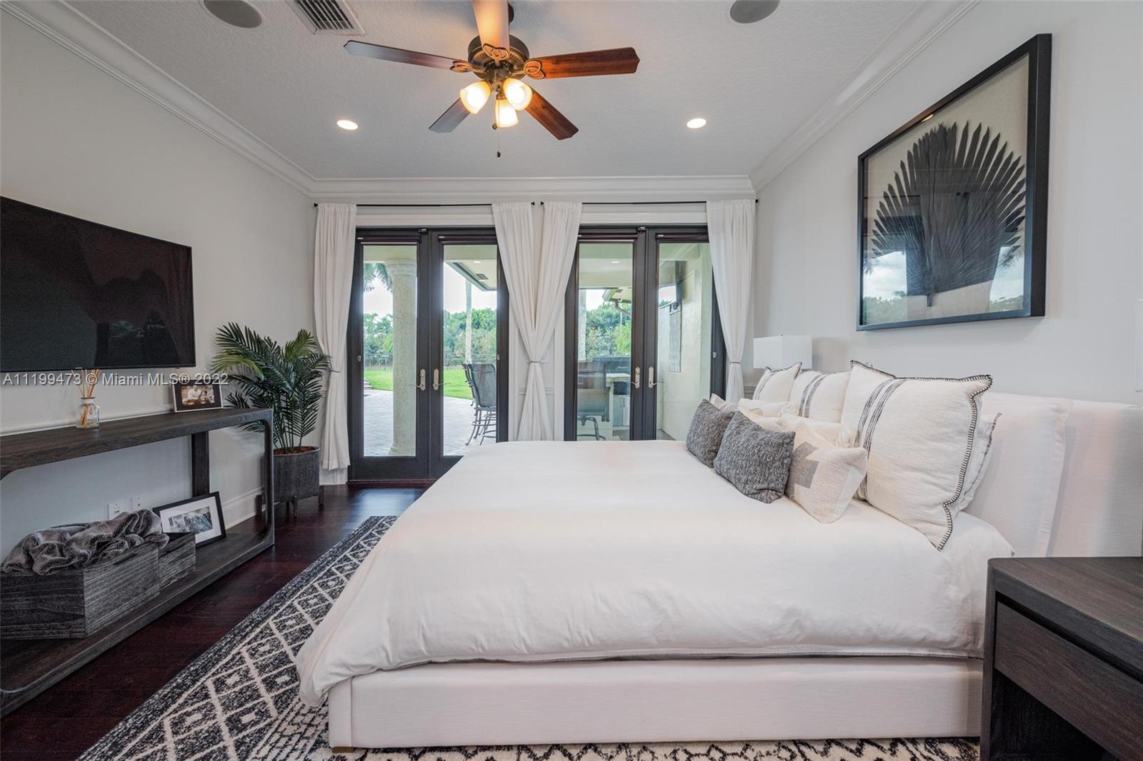 3510 Windmill Ranch Road Weston, FL 33331 - Photo 31 of 59 a bedroom with a large bed and a flat screen tv