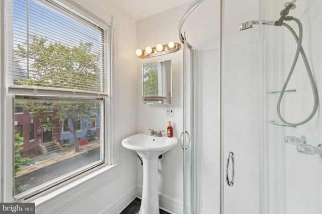 a bathroom with a sink a mirror and a window