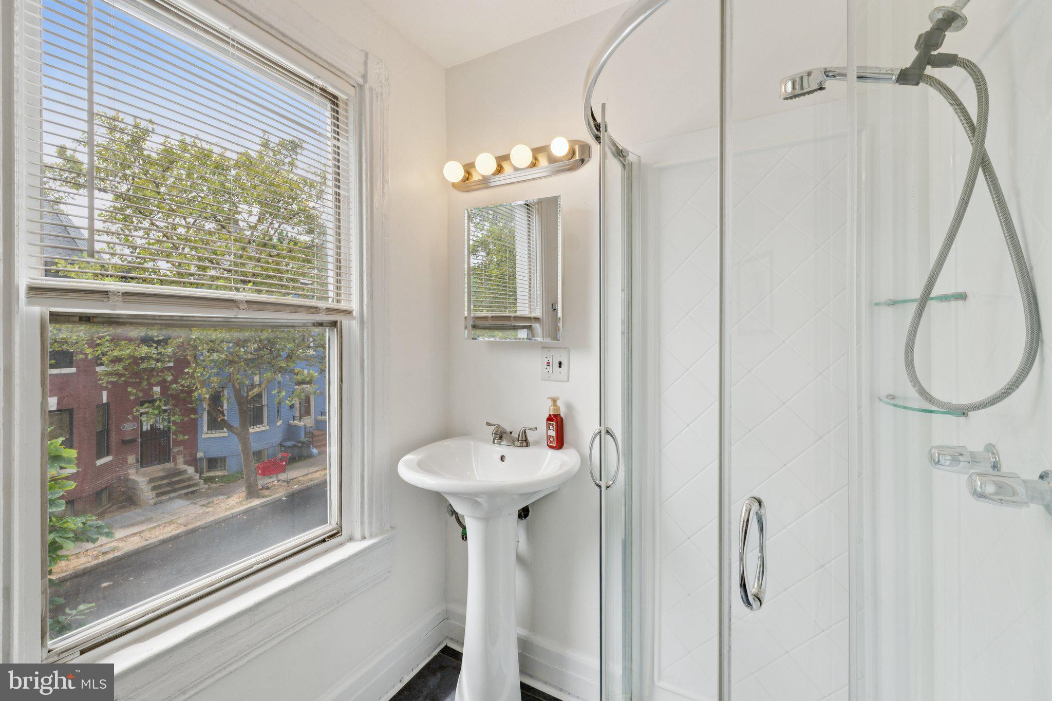 913 Columbia Road Northwest Washington, DC 20001 - Photo 16 of 37 a bathroom with a sink a mirror and a window