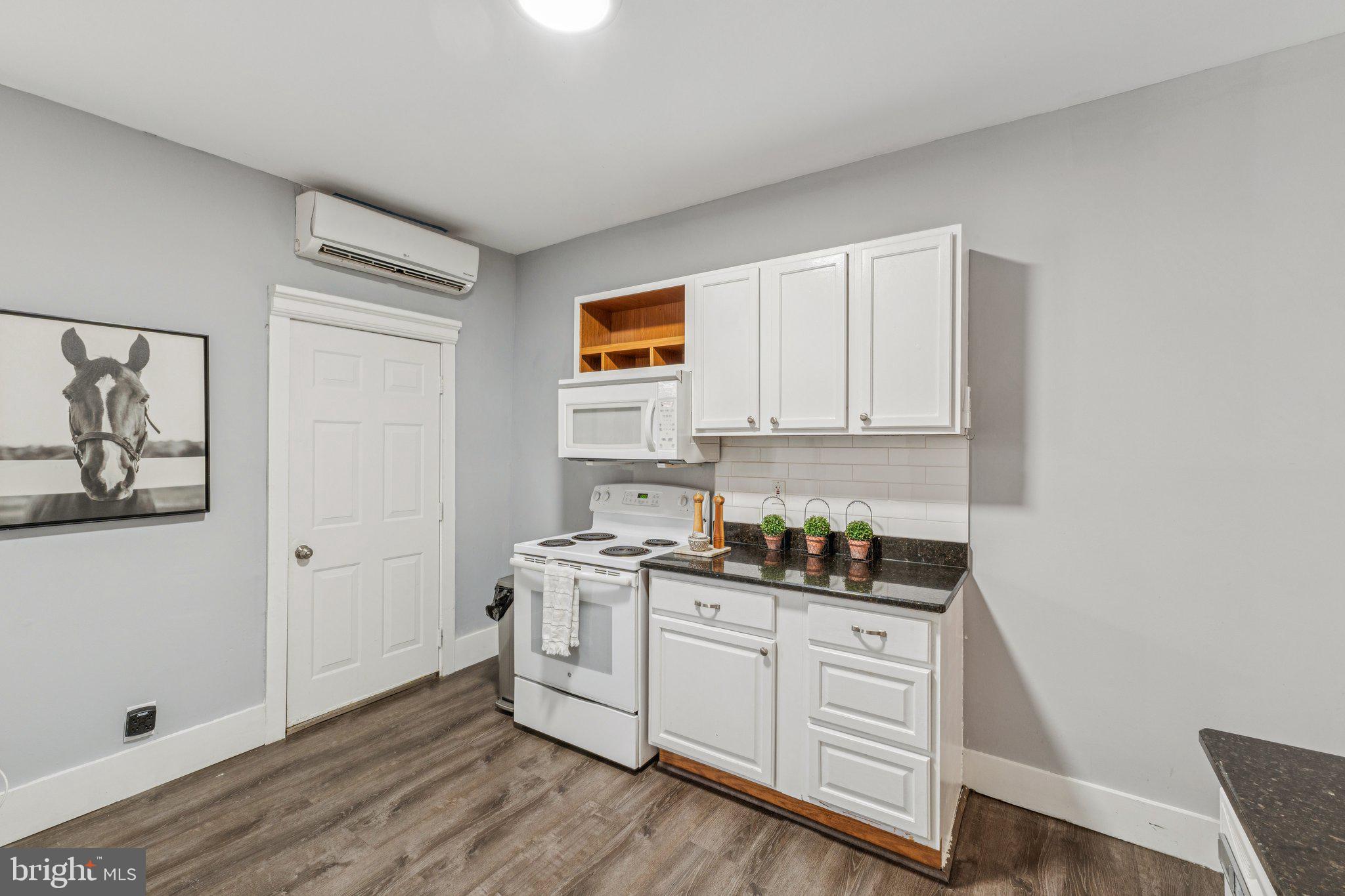 913 Columbia Road Northwest Washington, DC 20001 - Photo 8 of 37 a kitchen with white cabinets and wooden floor
