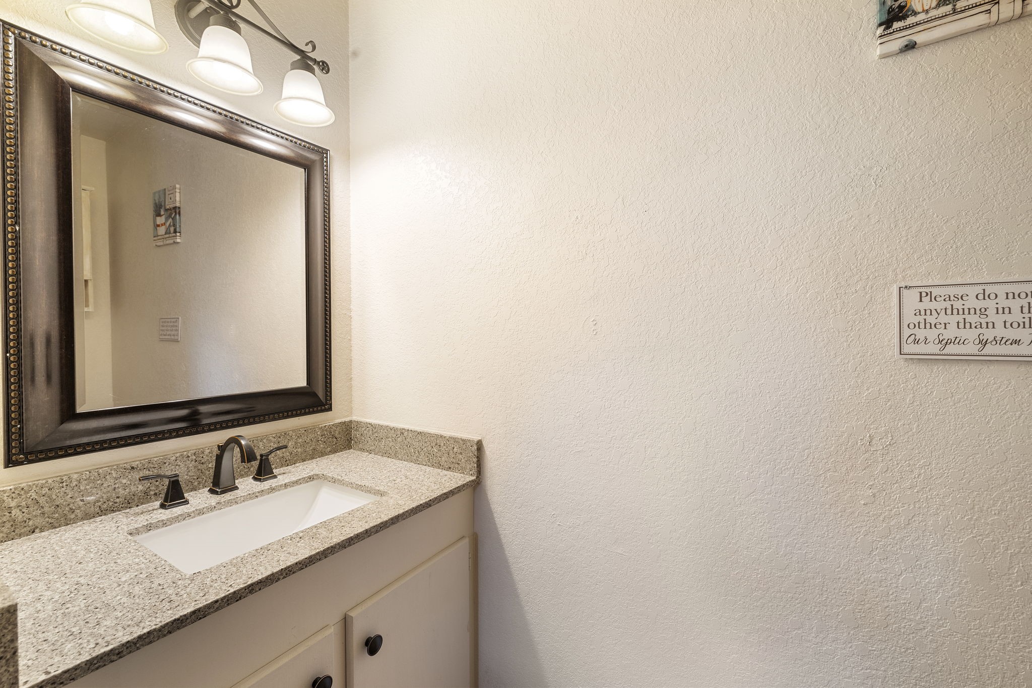 117 Cedar Rdg Lane Concan, TX 78838 - Photo 15 of 38 a bathroom with a granite countertop sink and a mirror