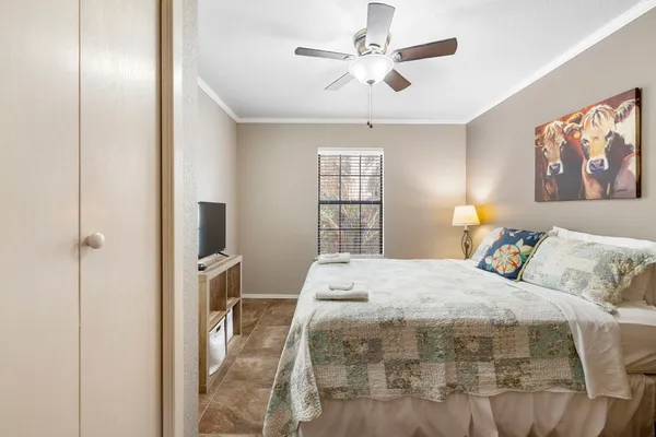 a bedroom with a large bed and a chandelier