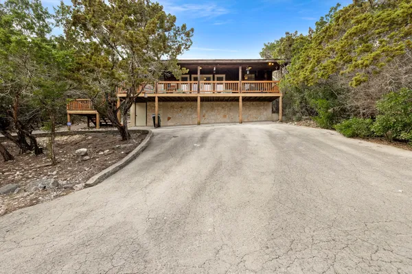 a view of a house with a yard and large tree