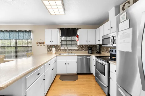 a kitchen with granite countertop white cabinets and white appliances