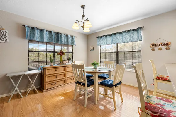 a dining room with wooden floor and windows