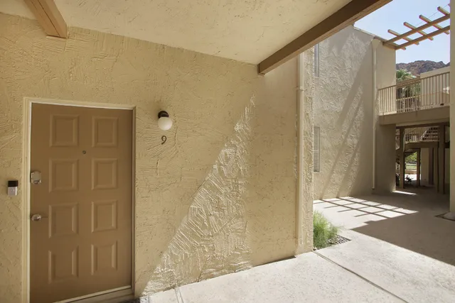 a view of a hallway with wooden floor and a bathroom