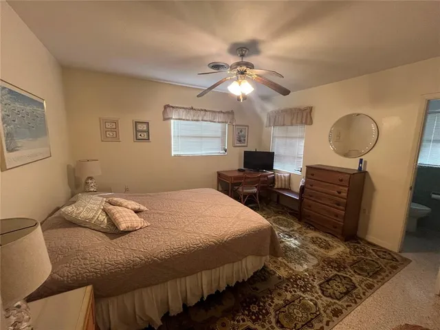 a spacious bedroom with a bed and a chandelier