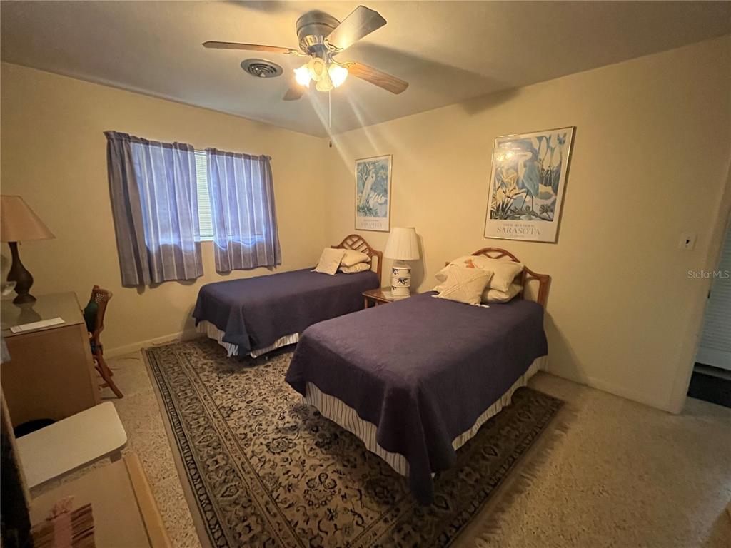 505 Granada Avenue Venice, FL 34285 - Photo 21 of 30 a bedroom with two beds and a chandelier