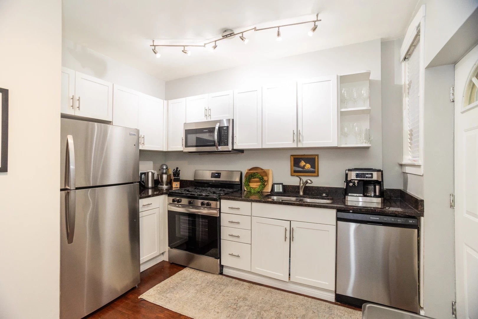 2026 North Burling Street, Unit 208 Chicago, IL 60614 - Photo 7 of 14 a kitchen with stainless steel appliances granite countertop a refrigerator a stove a sink a microwave and white cabinets