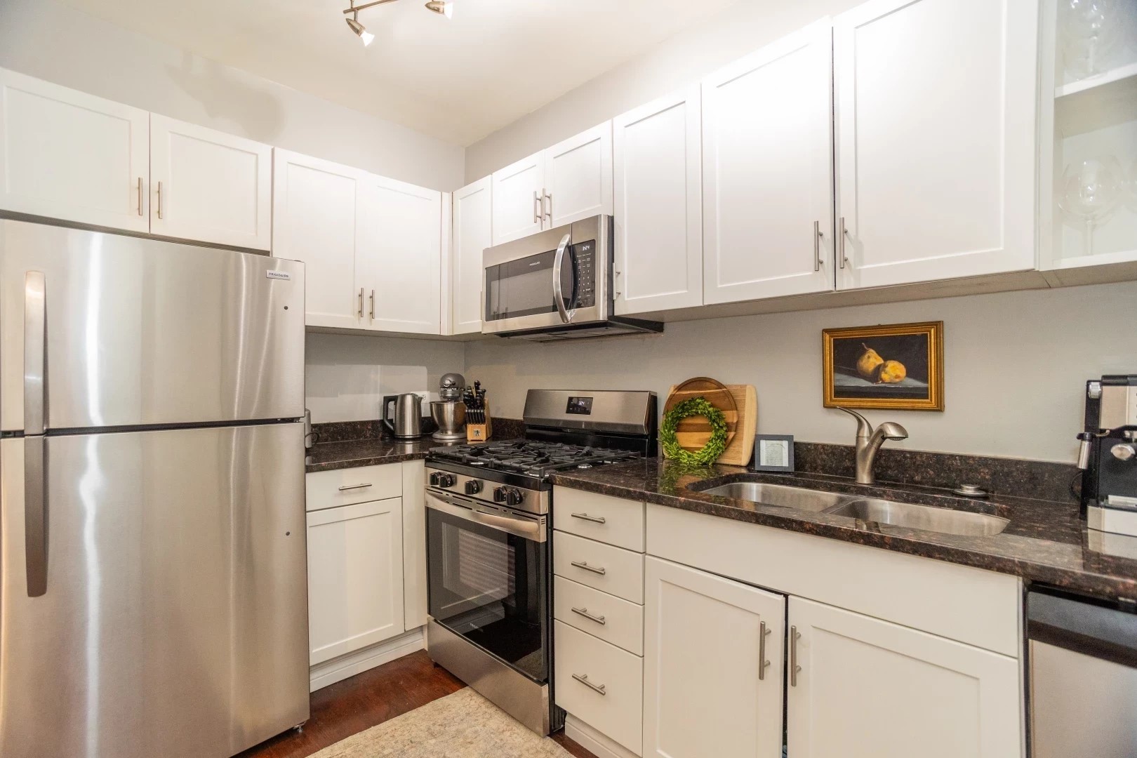2026 North Burling Street, Unit 208 Chicago, IL 60614 - Photo 8 of 14 a kitchen with stainless steel appliances granite countertop white cabinets a refrigerator a sink a stove and white cabinets