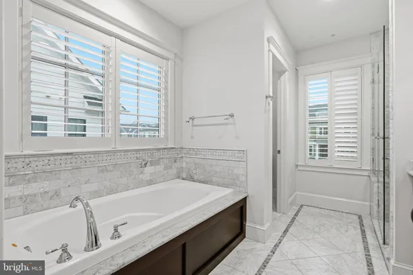 a bathroom with a tub a sink and a window