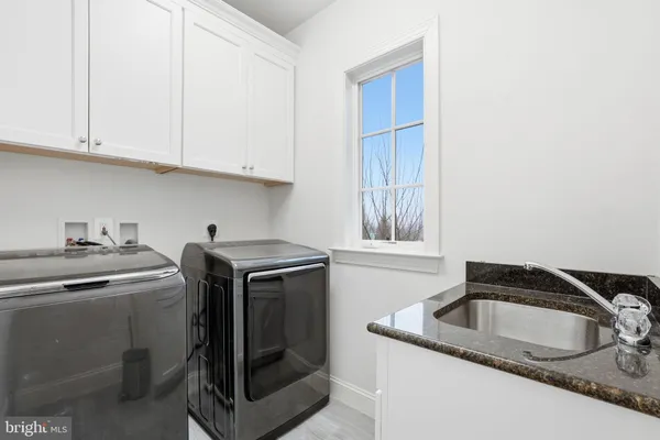 a utility room with sink dryer and washer