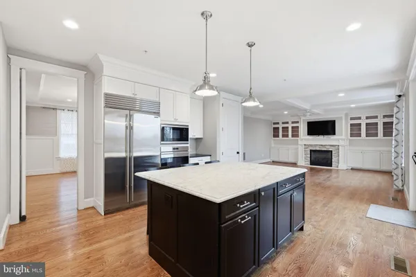 a large kitchen with stainless steel appliances kitchen island a large counter top and refrigerator