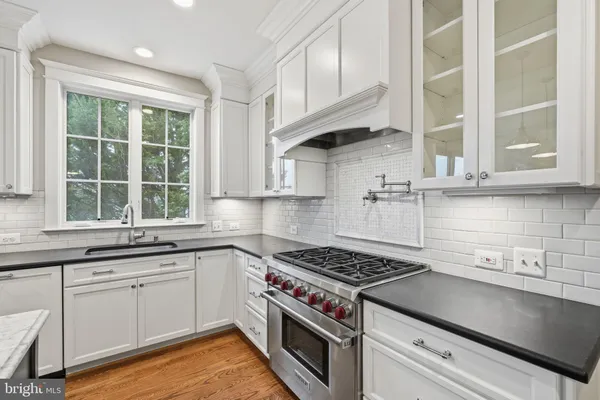 a kitchen with stainless steel appliances white cabinets and a stove