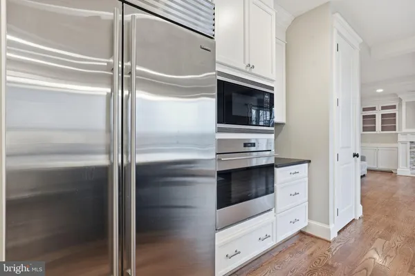 a kitchen with white cabinets and white appliances