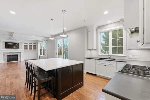 a kitchen with stainless steel appliances granite countertop a stove a sink a microwave a refrigerator a stove and white cabinets