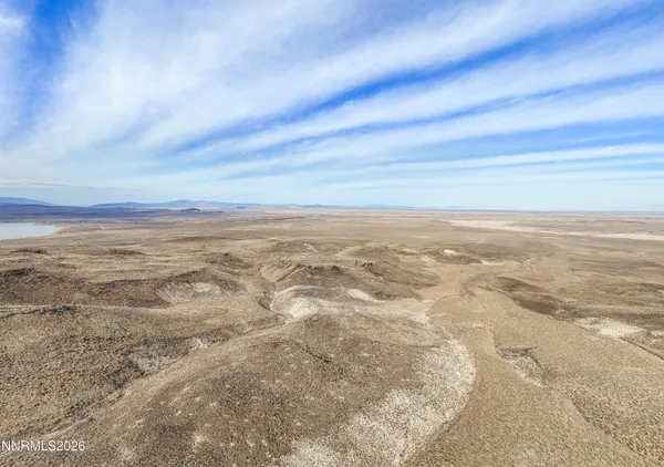 a view of a dry yard with mountains in the background