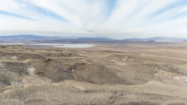 a view of a dry yard with mountains in the background