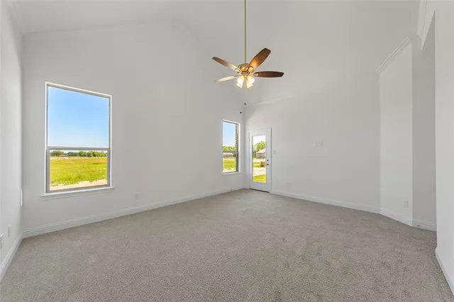 an empty room with a window and ceiling fan