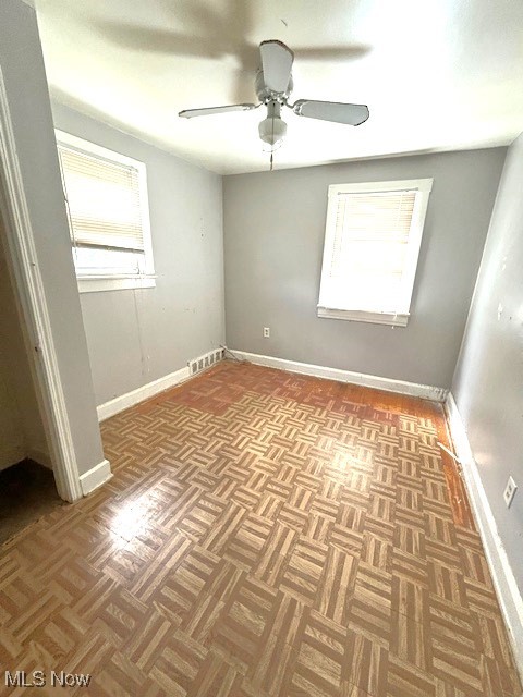 14628 Granger Road Maple Heights, OH 44137 - Photo 28 of 45 Empty room with ceiling fan, parquet flooring, and plenty of natural light