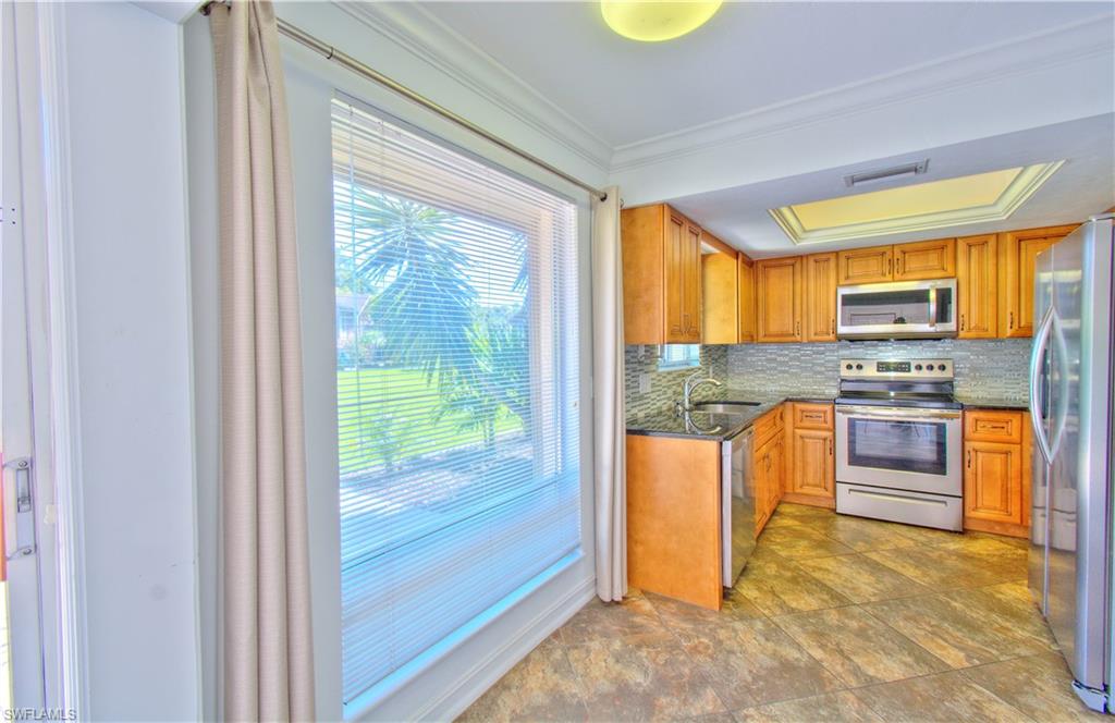 787 Palm View Drive, Unit 3 Naples, FL 34110 - Photo 11 of 27 a kitchen with stainless steel appliances granite countertop a refrigerator a stove top oven and a sink with granite countertops