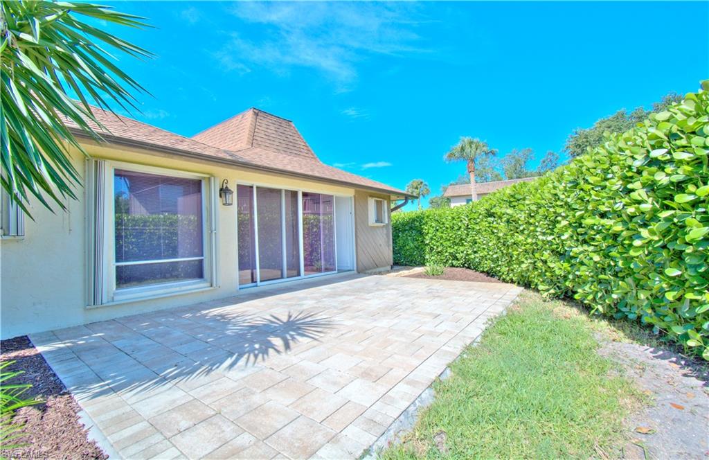787 Palm View Drive, Unit 3 Naples, FL 34110 - Photo 16 of 27 a front view of a house with a garden